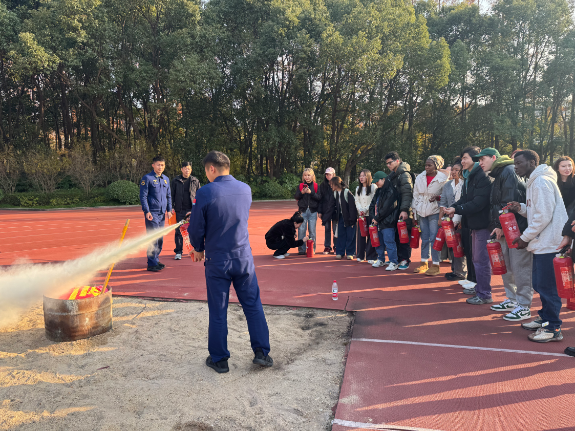 图为留学生参与灭火器实操培训