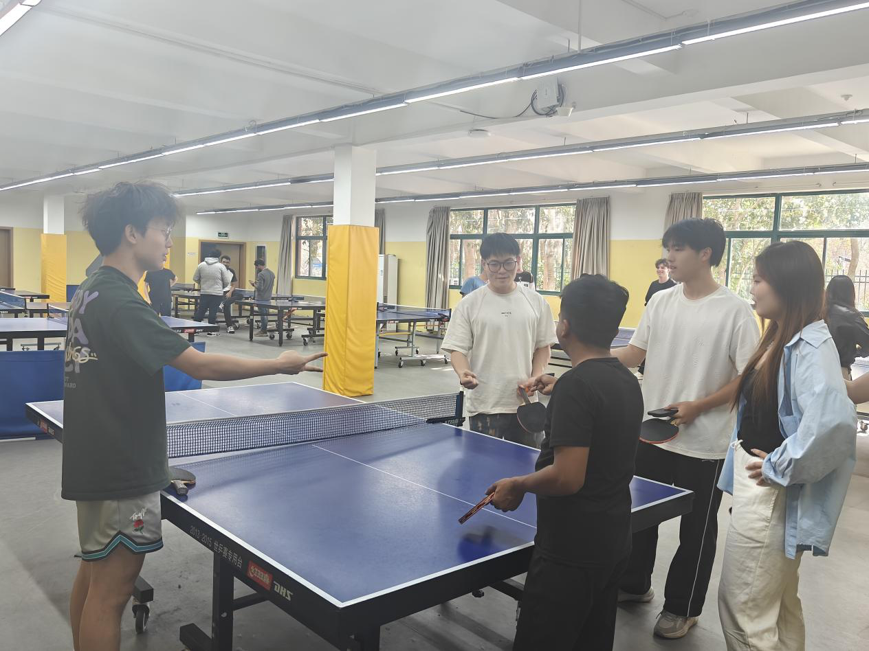Photo: A Chinese student demonstrates the serving techniques of ping pong